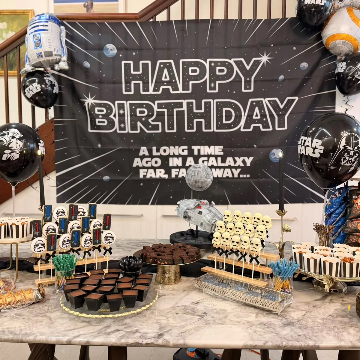 A Star Wars-themed dessert table with a celebration cake and coordinated sweet treats